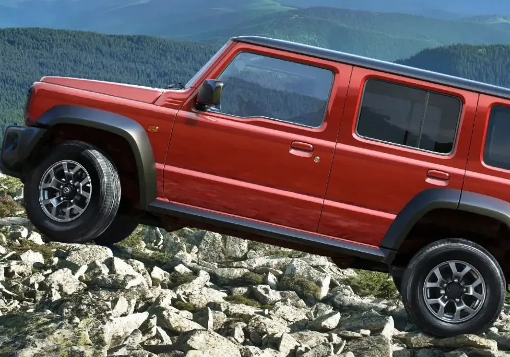 Suzuki Jimny roja de 5 puertas sube un sendero rocoso